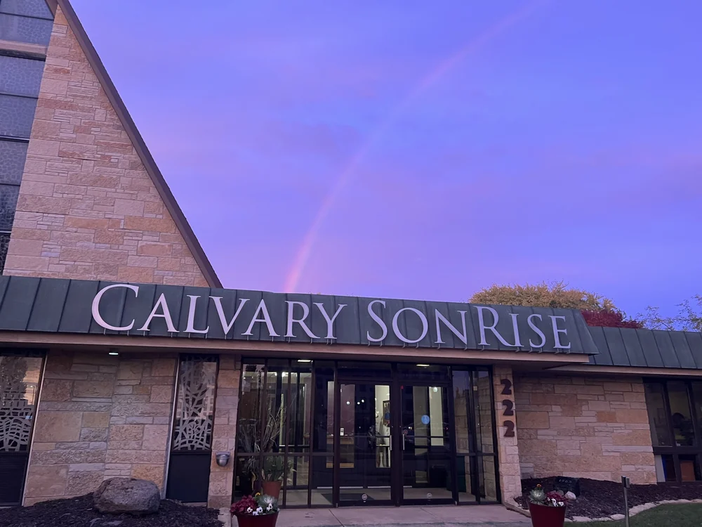 The entrance of Calvary SonRise at 222 Church Avenue, beneath a rainbow at dusk