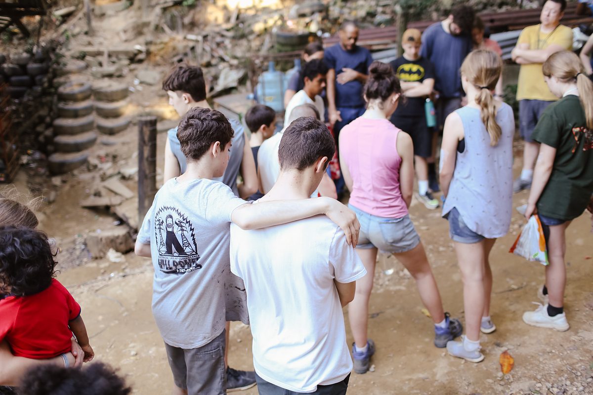 A SonRise Mission team praying together in a neighborhood in Roatán, Honduras