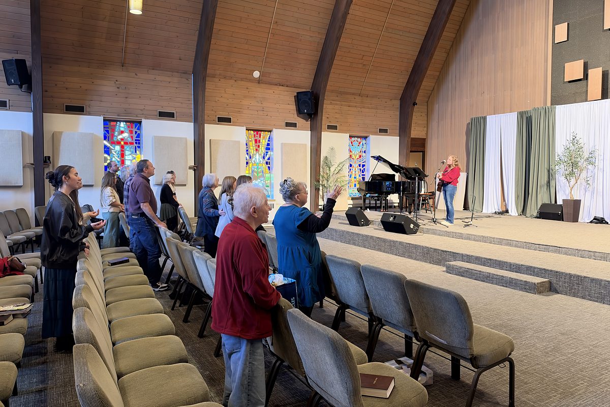 Worshiping together on a Sunday morning, with a Bible on a chair in the front row